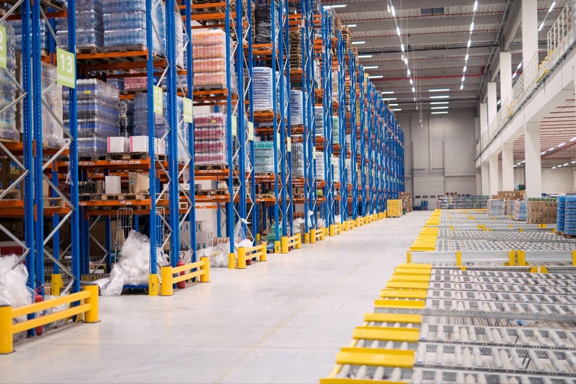 Cold-chain warehouse with storage racks and distribution conveyors